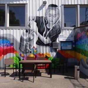 Eine bemalte Wand am Eingang eines Sozialkaufhauses.
